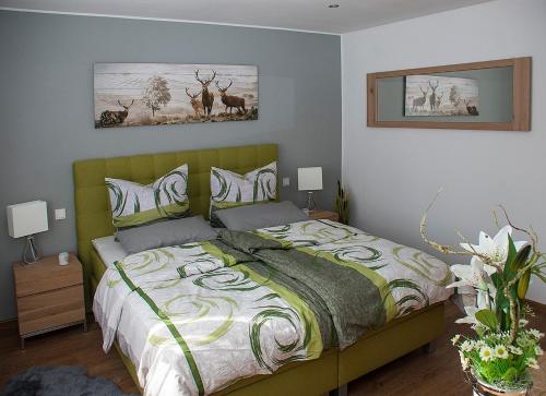a bedroom with a bed and two pictures on the wall at Hochwertige und moderne Ferienwohnung Huber in Neuweiler
