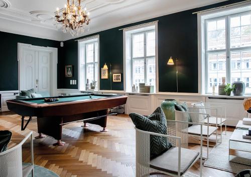ein Wohnzimmer mit einem Billardtisch und Stühlen in der Unterkunft Rungstedgaard in Rungsted