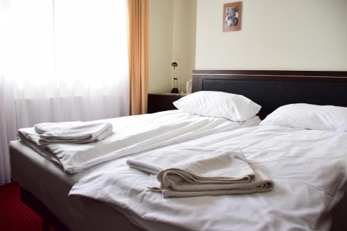 a bed with white sheets and towels on it at Willa Halka in Zakopane