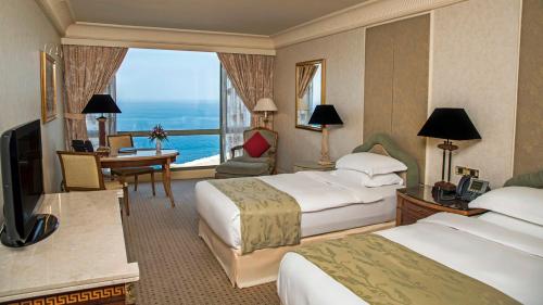 a hotel room with two beds and a desk at InterContinental Phoenicia Beirut by IHG in Beirut