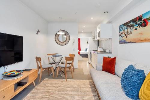 a living room with a couch and a table at Metro Living Apt near Skytower and Parking in Auckland