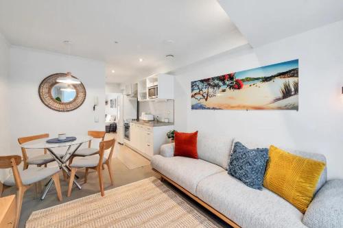 a living room with a couch and a table at Metro Living Apt near Skytower and Parking in Auckland