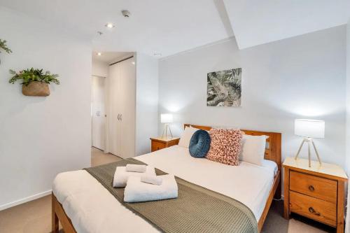 a bedroom with a bed with two towels on it at Metro Living Apt near Skytower and Parking in Auckland