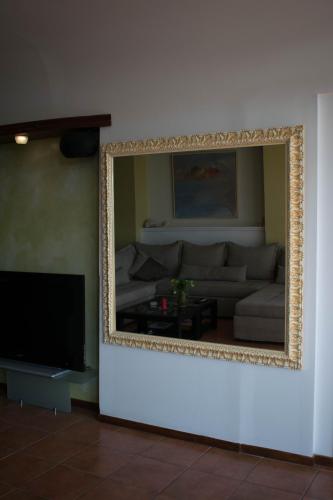 a mirror on a wall in a living room with a couch at Dolichi View in Pythagoreio