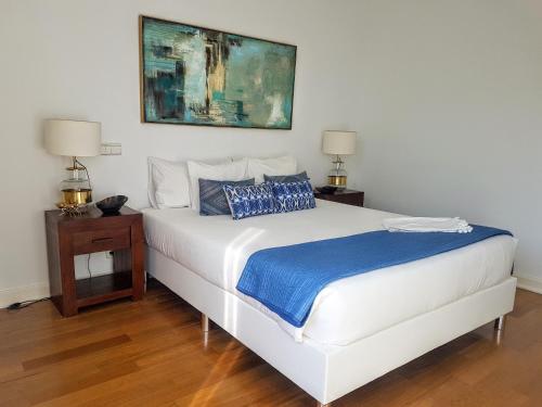 a white bed in a room with two night stands and two lamps at Modern Apartment Gulbenkian in Lisbon