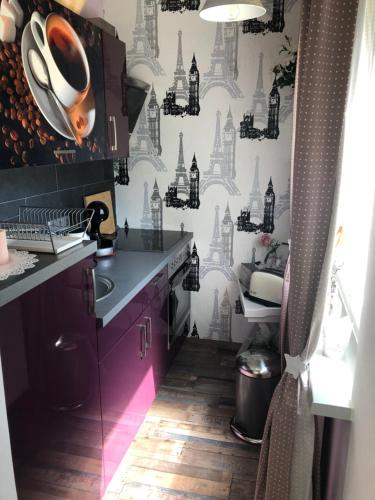 ライプツィヒにあるApartment Fritzの紫色のキャビネットと白黒の壁紙を使用したキッチン