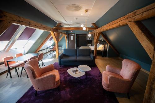 a living room with a couch and chairs and a table at Hotell Bondeheimen in Oslo