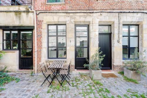 a table and chairs in front of a brick building at La Corderie in Lille