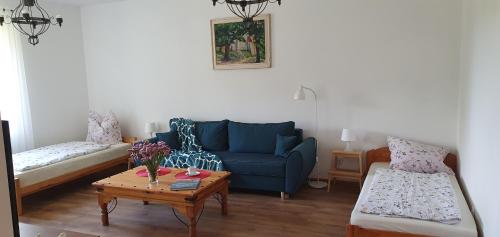 salon z niebieską kanapą i stołem w obiekcie Agroturystyka Chata Jana w mieście Chojnów