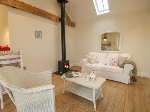 a living room with a white couch and a stove at March Hare in Ashbourne