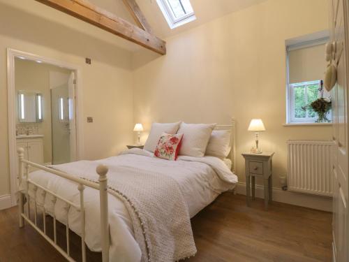 Schlafzimmer mit einem Bett mit weißer Bettwäsche und einem Fenster in der Unterkunft Barn Owl in Ashbourne