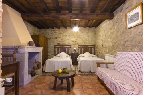 a living room with two beds and a fireplace at El Padre La Calle in El Torno