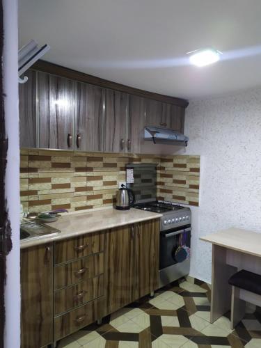 cocina con armarios de madera y fogones en Tatev Boutique Cottage, en Tatʼev