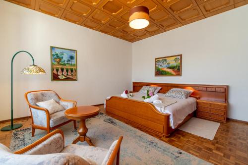 a bedroom with a bed and a chair at Refúgio Rural - Eco Villa in Caldas da Rainha