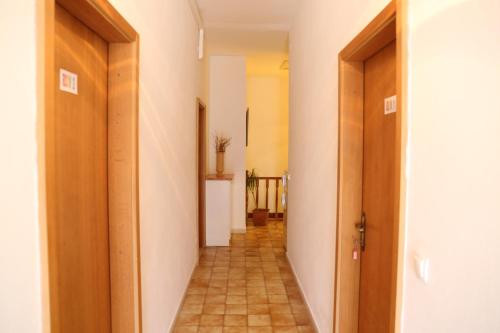 a hallway with two doors and a tile floor at Coosy rooms KATARINA in Lumbarda