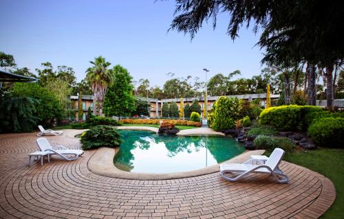 a swimming pool with two lounge chairs in a yard at Nightcap at York on Lilydale in Mount Evelyn