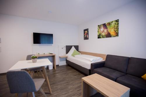 a living room with a couch and a table at Schoko Apartments in Unterschneidheim