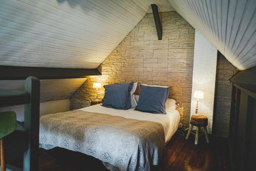 a bedroom with a bed in a brick wall at Au fil de l'eau in Fourges