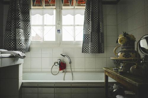 eine Badewanne im Bad mit Fenster in der Unterkunft Au fil de l'eau in Fourges