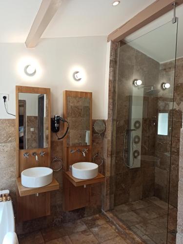 a bathroom with two sinks and a shower at La Villa Dune, Hôtel & Spa in Saint-Tropez