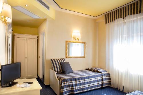 a hotel room with a bed and a television at Albergo Milano in Boario Terme