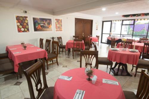 a dining room with red tables and chairs and tablesktop at Hotel Casino Plaza in Guadalajara
