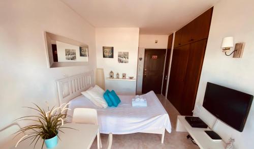 a small room with a bed and a television at Apartamento Praia do Alvor in Alvor