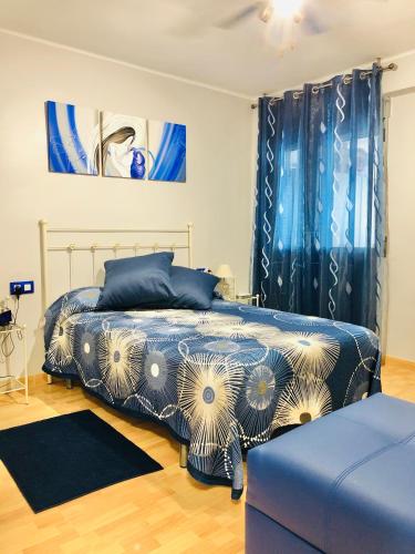 a bedroom with a bed with a blue and white comforter at CENTRICO LABRADORES 15 in Peniscola