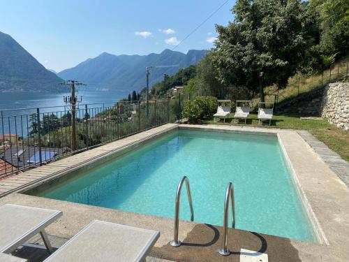 a swimming pool with chairs and a view of the water at Residence Sala Comacina apartment no 2 with pool and spa by Italian Apartments in Isola Comacina