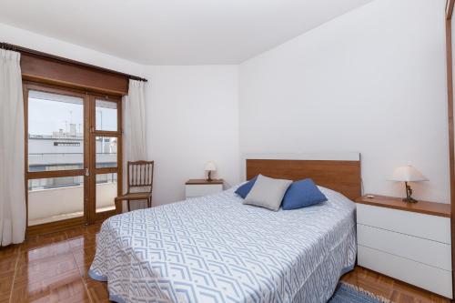 sypialnia z łóżkiem i dużym oknem w obiekcie Casa da Praia w Armação de Pêra