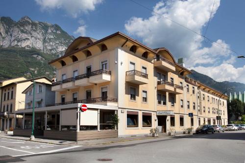 a building on the corner of a street with a mountain at Albergo Milano in Boario Terme