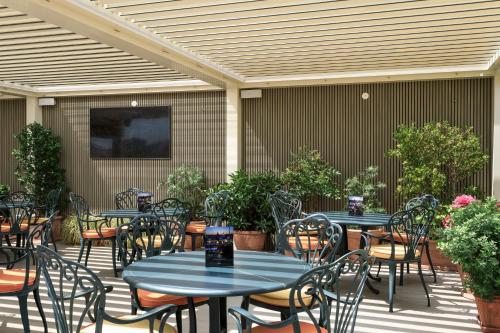 an outdoor patio with tables and chairs and plants at Marcella Royal Hotel - Rooftop Garden in Rome