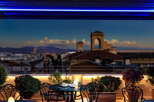 a balcony with a table and chairs and a building at Marcella Royal Hotel - Rooftop Garden in Rome