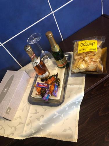 a table with a tray of food and two bottles of alcohol at Ubytování v soukromí rodinné vily v Děčíně in Děčín