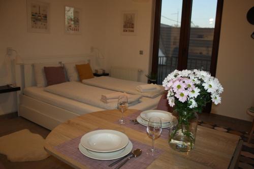 a room with a table with plates and flowers on it at Studio apartman Centar in Ðakovo