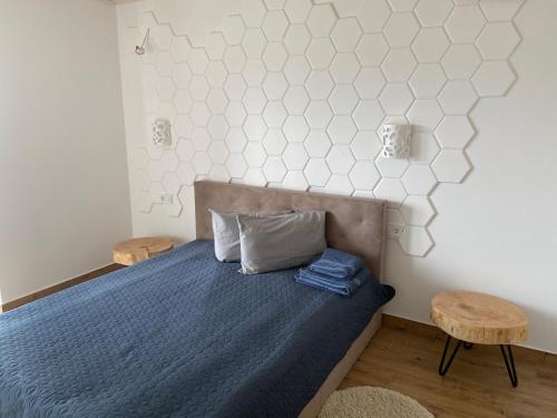 a bedroom with a bed with a blue comforter and two chairs at Panorama Karpat in Yablunytsya
