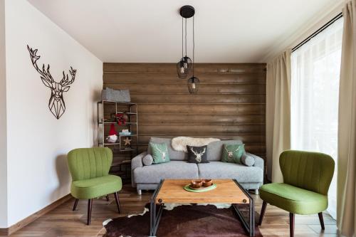 a living room with a couch and two chairs at Chalets Royal, Tatranská Lomnica in Tatranská Lomnica