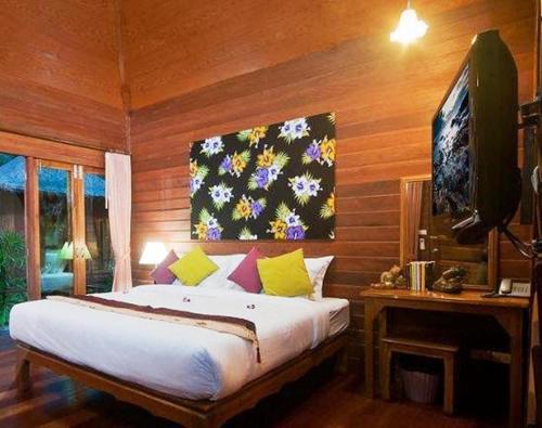 een slaapkamer met een groot bed en een televisie bij Lipa Bay Resort in Lipa Noi