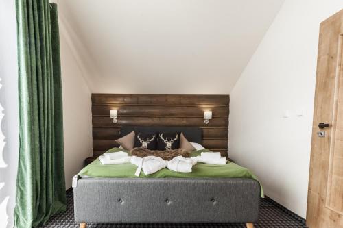 a bedroom with a bed with two towels on it at Chalets Royal, Tatranská Lomnica in Tatranská Lomnica
