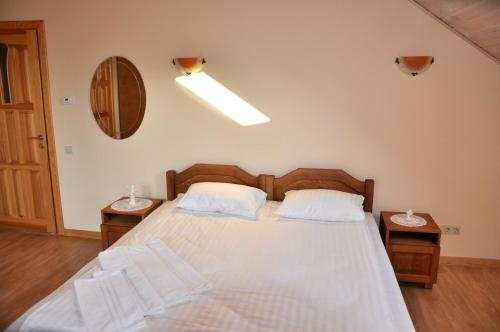 a bedroom with a large bed with two night stands at Jūrvingė in Žadvainai