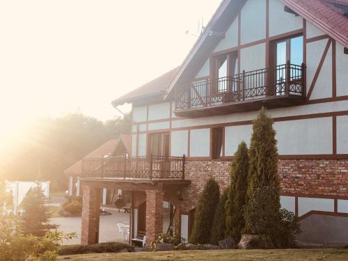 a large building with a balcony on the side of it at Jūrvingė in Žadvainai