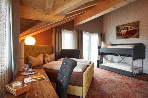 a bedroom with a bunk bed and a table at Vintage Hotel Charivari- Sommer Hörnerbahnen kostenlos mit Restaurant in Bolsterlang