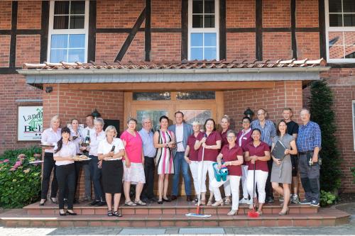 a group of people standing in front of a brick building at Landhotel Behre in Lehrte
