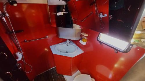 a red bathroom with a toilet and a sink at Sleep Over Water in Lisbon in Lisbon