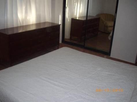 a bedroom with a bed and a large mirror at Dre Broeders Apartments Juan Dolio in Juan Dolio
