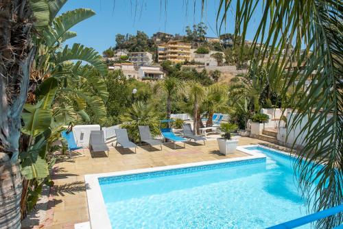 a swimming pool with palm trees and a resort at Villa Oleandro in Alcamo Marina