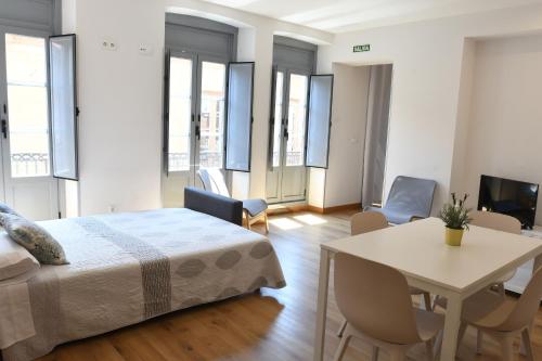 a bedroom with a bed and a table and chairs at Housingleón - Apartamentos Fauno in Astorga