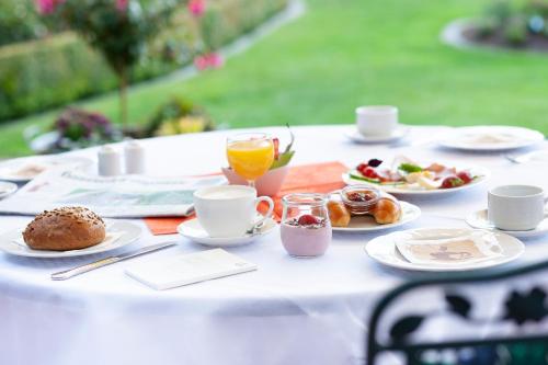 a white table with plates of food and drinks on it at Landhotel Behre in Lehrte