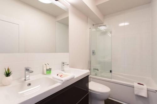 a bathroom with a sink and a toilet and a shower at Live Like a Local in this Superb Loft by Den Stays in Montréal