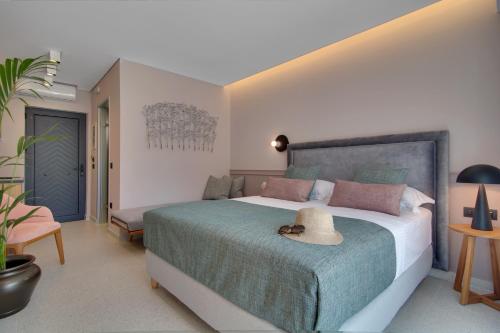 a bedroom with a large bed with a hat on it at Charisma Boutique Hotel in Parga